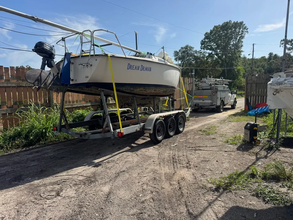 Sailboat secured with yellow straps on a multi-axle trailer