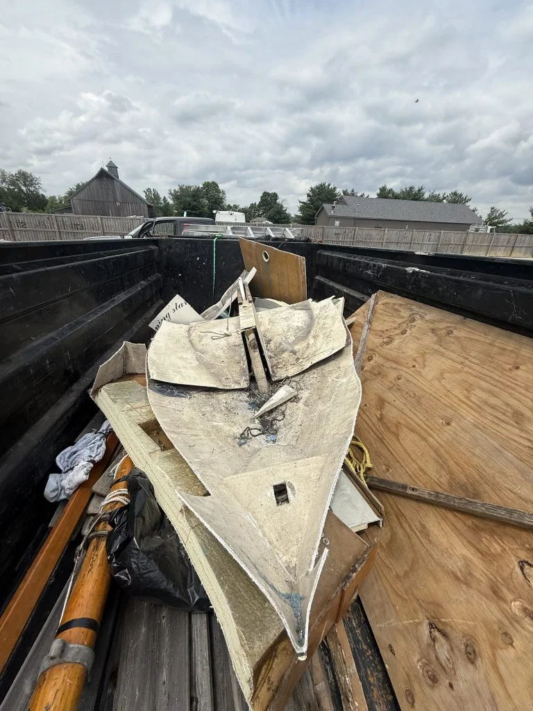 Small pale hull lying among materials inside a container