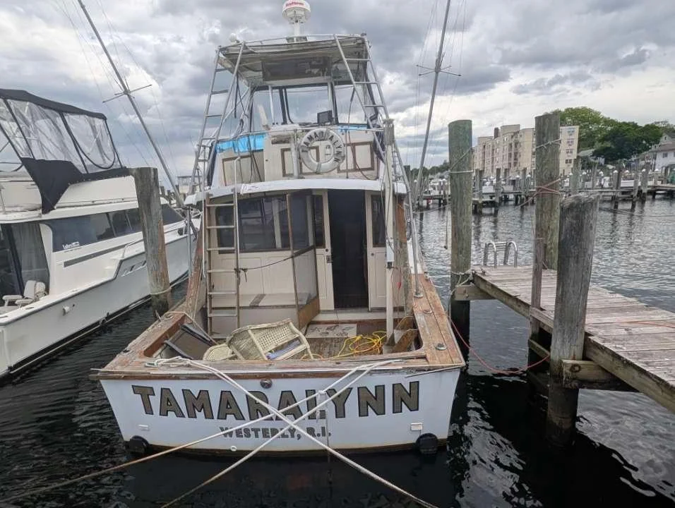 Weathered stern and cabin entrance between wooden dock pilings