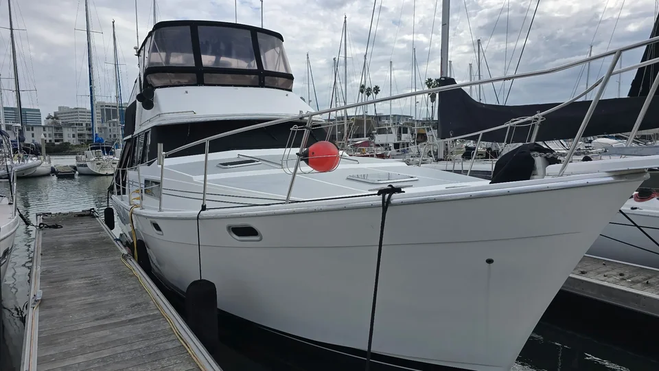 White cabin yacht moored beside a wooden marina walkway